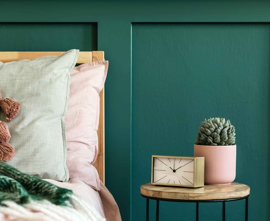 Stylish-bedroom-interior-with-design-coffee-table-plant-gold-clock-and-elegant-personal-accessories